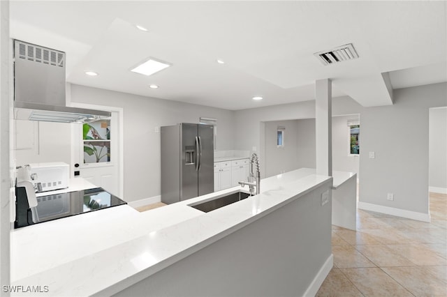 kitchen featuring extractor fan, light tile patterned flooring, sink, stainless steel fridge, and range