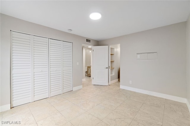 unfurnished bedroom featuring a walk in closet and a closet