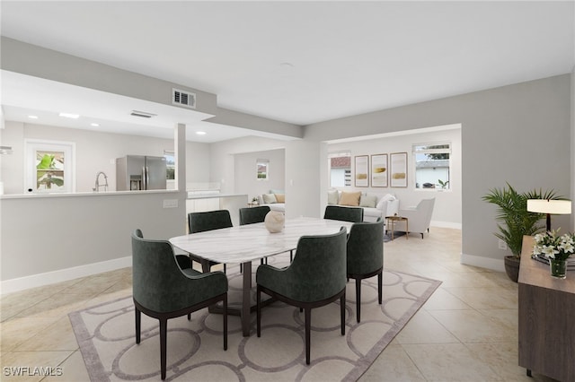 tiled dining area featuring plenty of natural light and sink