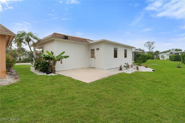 rear view of property with a patio and a yard