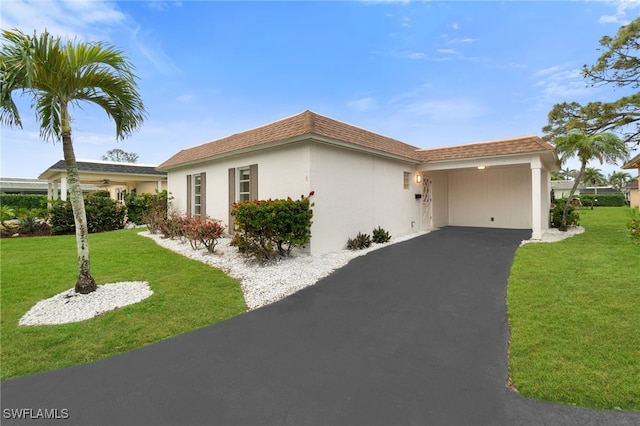 view of front of house with a carport and a front lawn