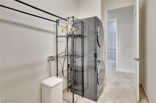 washroom with stacked washer and dryer and light tile patterned flooring