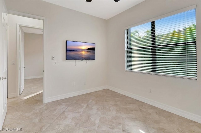 tiled spare room featuring ceiling fan