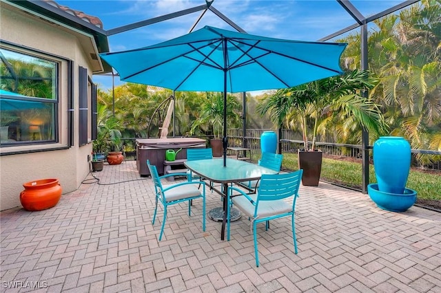 view of patio with glass enclosure and a hot tub