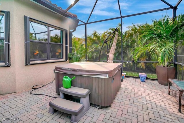 view of patio featuring a lanai and a hot tub