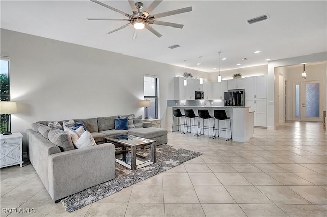 living room featuring ceiling fan, plenty of natural light, and light tile patterned floors