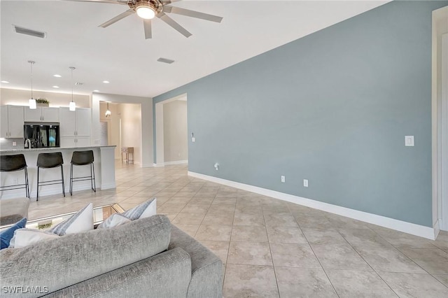 tiled living room featuring ceiling fan