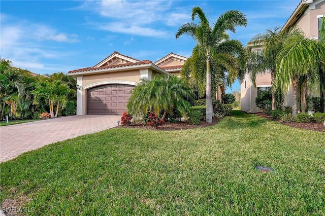 mediterranean / spanish house with a front lawn and a garage