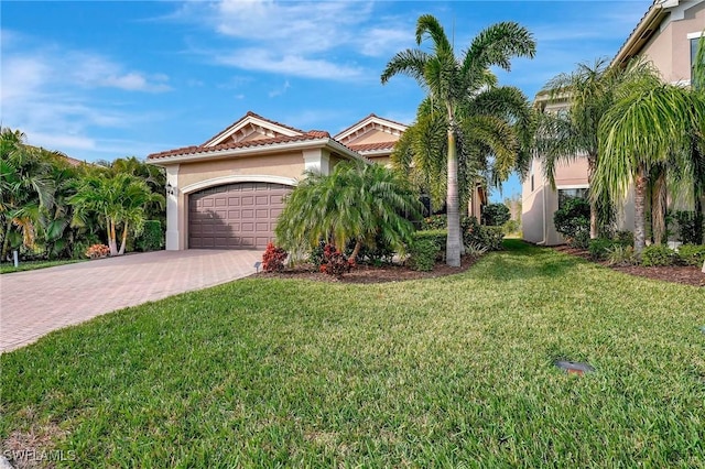 mediterranean / spanish house with a garage and a front lawn