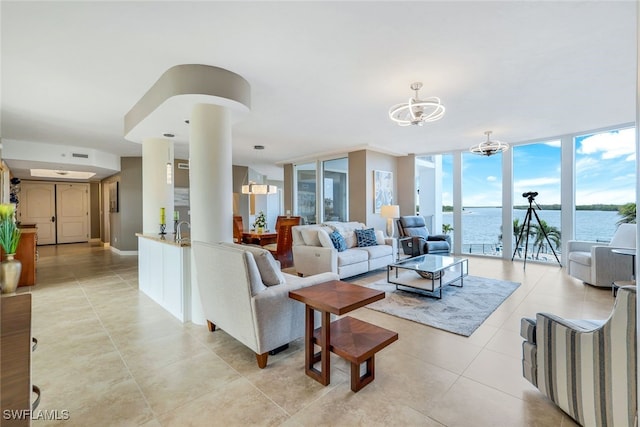 tiled living room with sink, expansive windows, a water view, and a notable chandelier