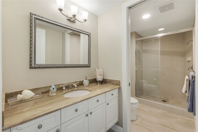 bathroom with toilet, a shower with door, and vanity