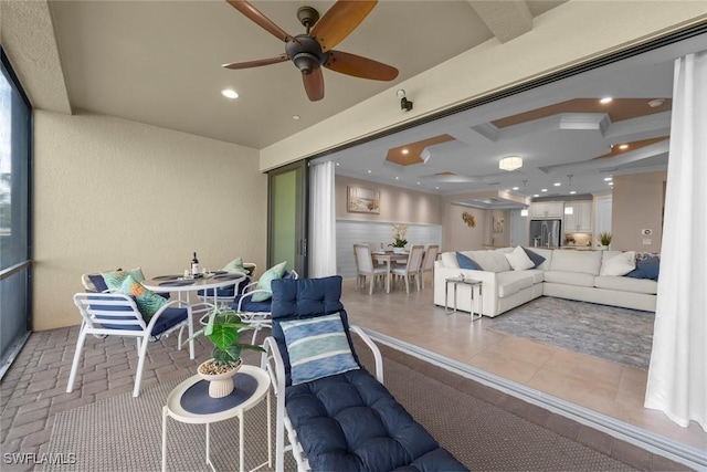 living room featuring coffered ceiling and ceiling fan