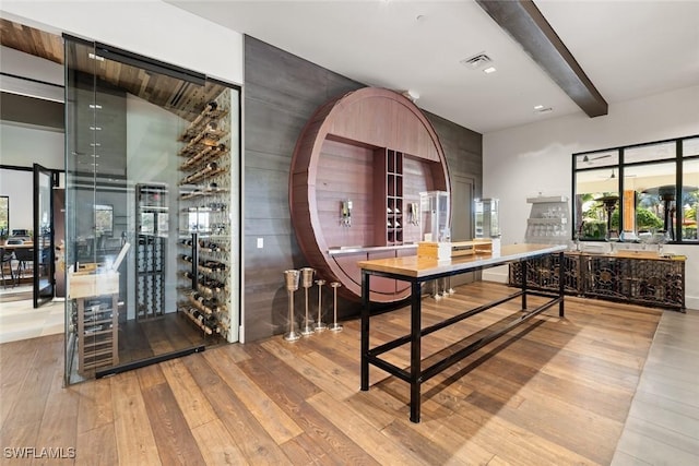 dining space with beamed ceiling and light hardwood / wood-style floors