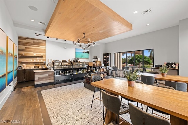 dining room with dark wood-type flooring and a chandelier