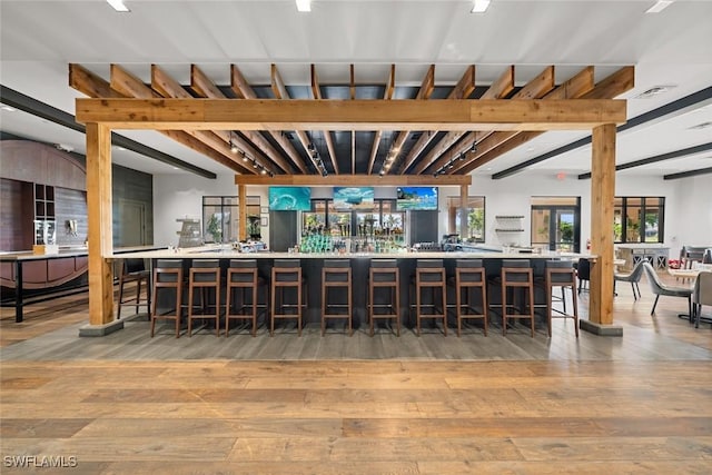 bar with beamed ceiling and wood-type flooring