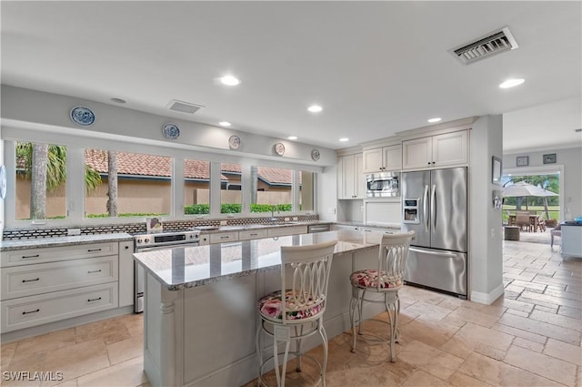 kitchen featuring light stone countertops, appliances with stainless steel finishes, and a center island