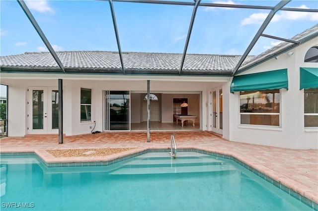 rear view of property featuring french doors, a lanai, and a patio