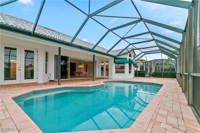 view of swimming pool featuring french doors, a lanai, and a patio