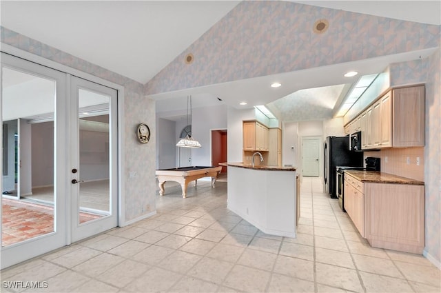 kitchen with lofted ceiling, pendant lighting, range, tasteful backsplash, and french doors