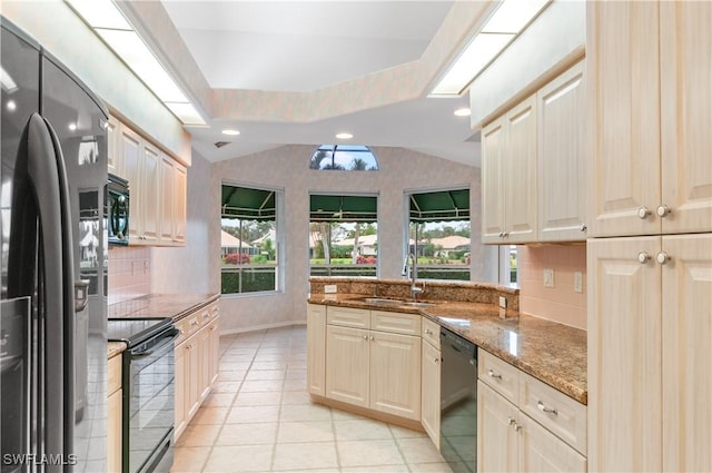 kitchen with light tile patterned flooring, lofted ceiling, sink, light stone counters, and black appliances