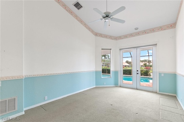 empty room with french doors, ceiling fan, and carpet flooring