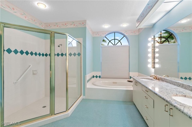 bathroom with vanity, a textured ceiling, and separate shower and tub