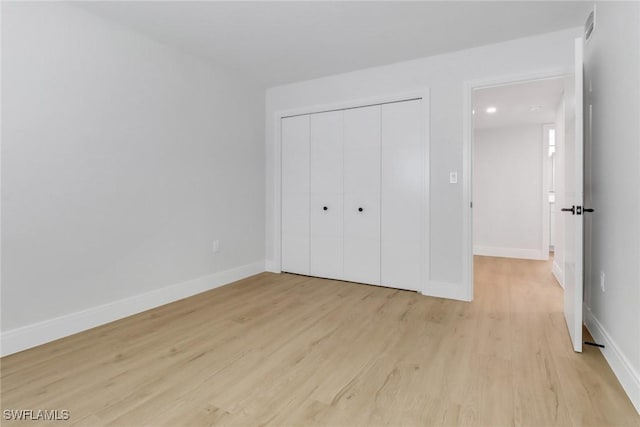 unfurnished bedroom featuring a closet and light hardwood / wood-style flooring