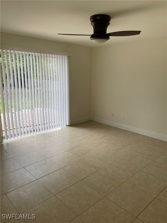 spare room with ceiling fan and light tile patterned floors