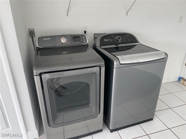 washroom with washer and clothes dryer and light tile patterned flooring