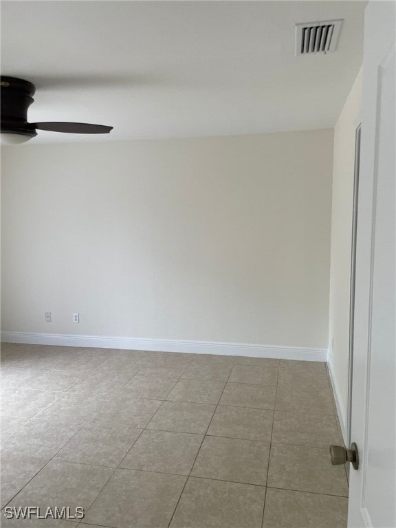 tiled spare room featuring ceiling fan