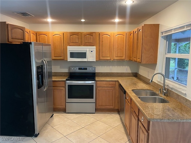 kitchen featuring light tile patterned floors, appliances with stainless steel finishes, and sink