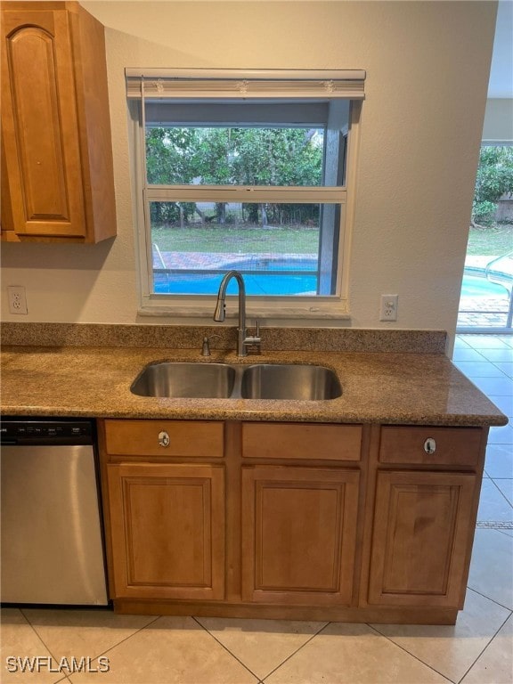 kitchen featuring light tile patterned floors, dishwasher, and sink