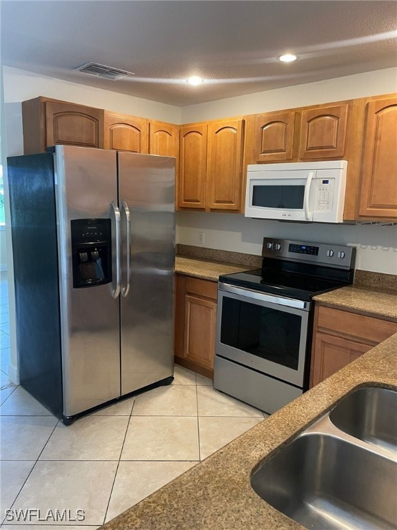 kitchen featuring light tile patterned floors, appliances with stainless steel finishes, and sink