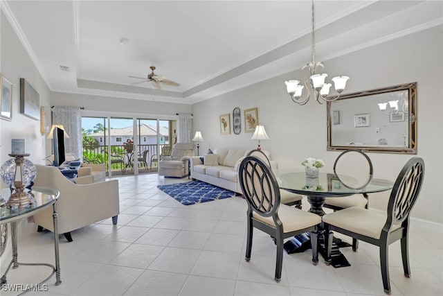 dining area with crown molding, light tile patterned floors, ceiling fan with notable chandelier, and a raised ceiling