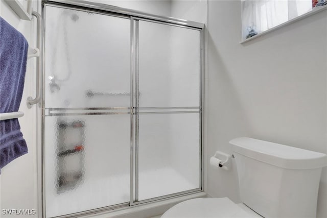 bathroom with an enclosed shower and toilet