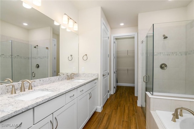 bathroom with a shower with shower door, hardwood / wood-style floors, and vanity