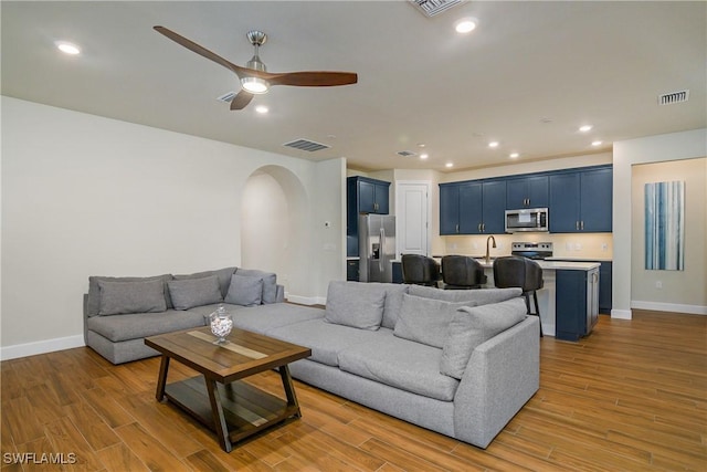 living room featuring ceiling fan and sink