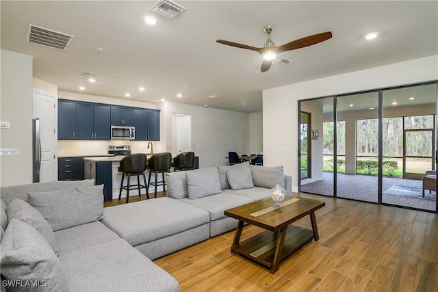 living room featuring ceiling fan and light hardwood / wood-style flooring