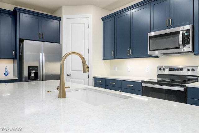 kitchen featuring appliances with stainless steel finishes and blue cabinets