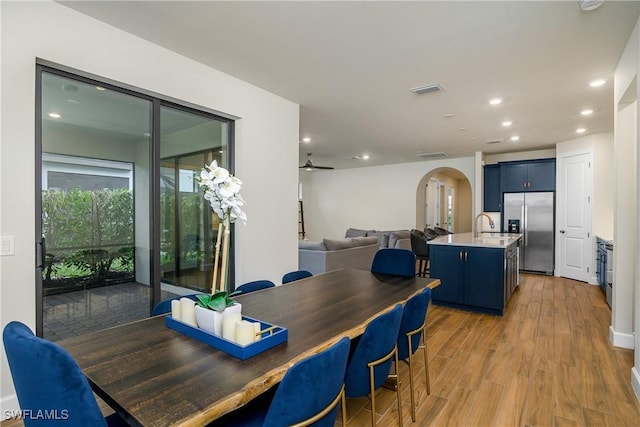 dining area featuring ceiling fan, sink, and light hardwood / wood-style flooring