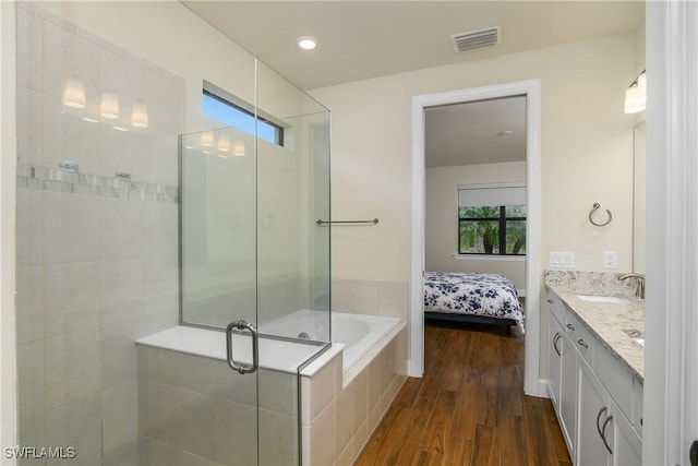 bathroom with separate shower and tub, vanity, and hardwood / wood-style flooring