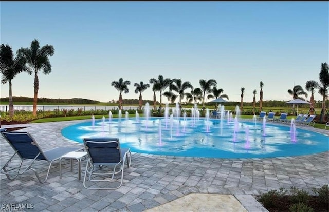 view of swimming pool featuring pool water feature and a patio