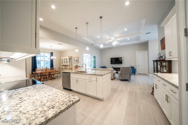 kitchen with light stone counters, sink, dishwasher, and an island with sink