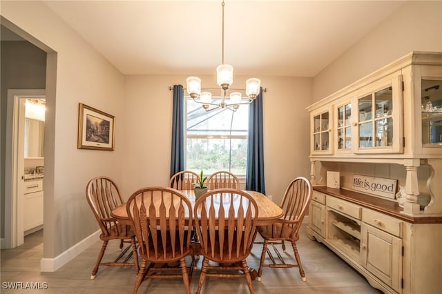 dining area with a notable chandelier and light hardwood / wood-style floors