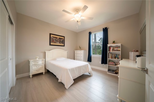 bedroom featuring ceiling fan, a closet, and light wood-type flooring