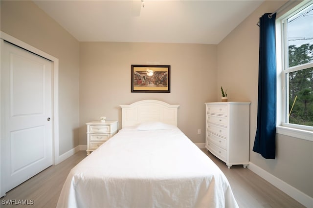 bedroom featuring ceiling fan, a closet, and light wood-type flooring