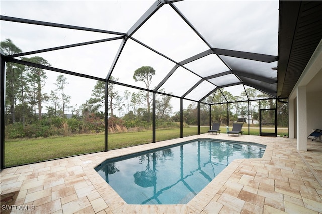 view of swimming pool featuring glass enclosure, a patio area, and a lawn