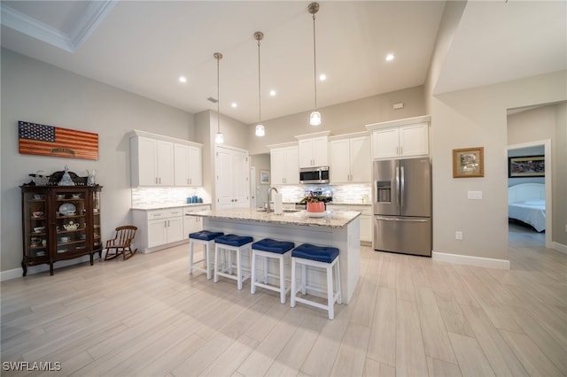 5435 Montego Ln, Port Charlotte, FL 33981 - kitchen with stainless steel appliances, a sink, a kitchen breakfast bar, decorative backsplash, and light wood-type flooring