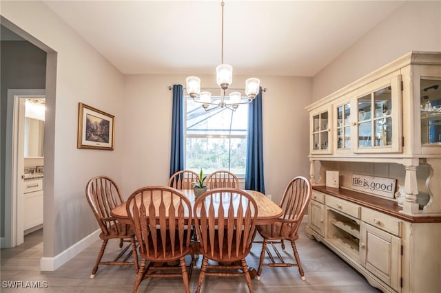 5435 Montego Ln, Port Charlotte, FL 33981 - dining area featuring a chandelier, baseboards, and light wood-type flooring