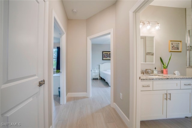 5435 Montego Ln, Port Charlotte, FL 33981 - hallway with light wood-style floors, a sink, and baseboards